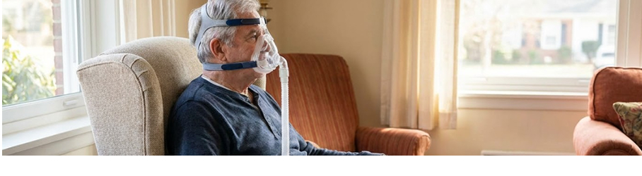COPD patient using mask-based ventilator support at home near a window